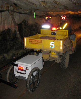 The MineComms Mapper™ is being towed by a mine jeep. The hand-tow bar is in its rest. The passenger is holding the tablet computer.